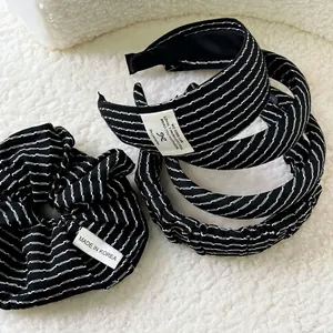 Minimalist black and white striped headband set with scrunchie on white sherpa background