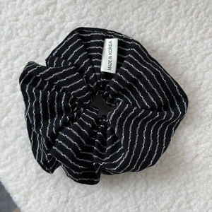 Detailed view of a black and white striped scrunchie with a Made in Korea woven label