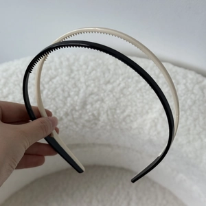 Détail de serre-têtes en acrylique crème et noir avec dents antidérapantes pour la coiffure