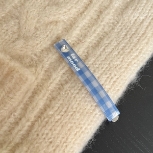 Fermaglio per capelli a quadri blu con strass a cuore su maglione beige