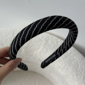Detail of hand made striped knit headband showing premium texture and internal woven label