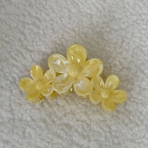 Détail d'une pince à cheveux fleur de frangipanier avec texture marbrée jaune et blanc