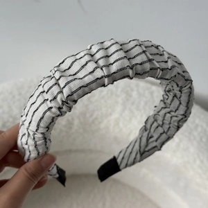 Detail of ruched black and white striped fabric headband with textured finish