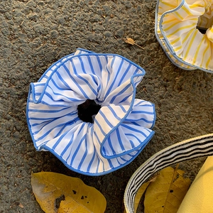Yellow and blue striped scrunchies set on asphalt background with autumn leaves