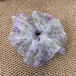 Détail d'un chouchou floral avec tissu organza translucide et finitions violettes