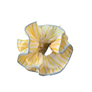 Yellow and white striped scrunchie with blue edging on a clean white background