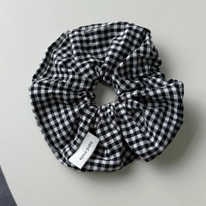 Detailed view of handmade black and white plaid scrunchie with hand made label