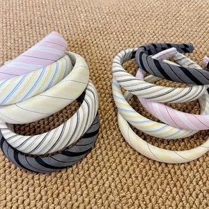 Striped sponge headbands for women in various colors on a natural woven background