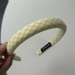 Detail of yellow gingham fabric headband with handmade label and padded structure