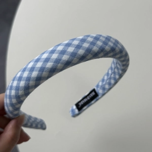 Detailed view of the blue gingham padded headband with a hand made woven label