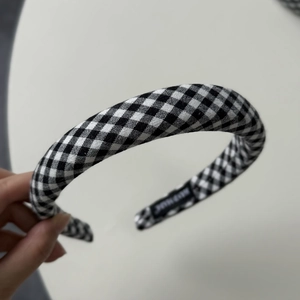 Detailed close-up of a handmade black and white gingham padded headband with soft sponge