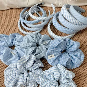 Detailed view of light blue striped and checkered padded headband with matching scrunchie
