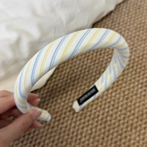 Detailed view of striped sponge headband with handmade black woven label interior