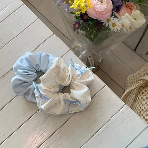 Set of two sea salt blue scrunchies featuring solid sky blue fabric and polka dot bow detail