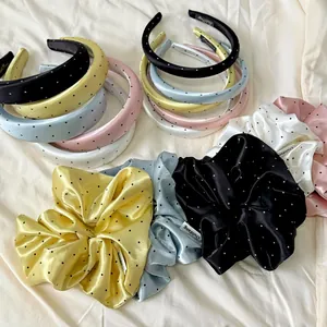Detailed view of polka dot satin headbands and scrunchies set in various pastel colors