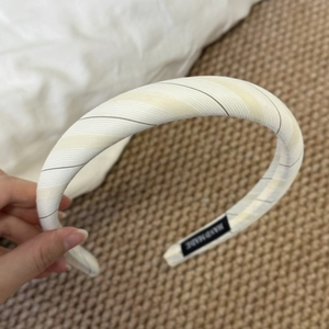 Detail of striped sponge headband showing handmade label and thick fabric texture