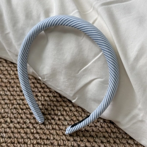 Detailed close-up of a blue and white striped fabric headband on a woven mat
