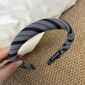 Detailed close-up showing white HANDMADE lettering on a striped sponge headband