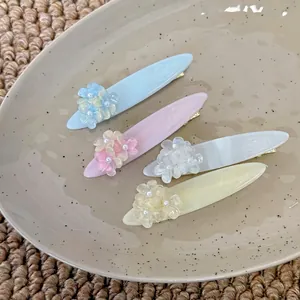 Lot de quatre barrettes à fleurs pastel en bleu, rose, blanc et jaune doux