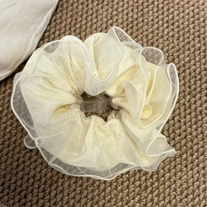 Détails de plis superposés sur un chouchou géant en organza de couleur crème