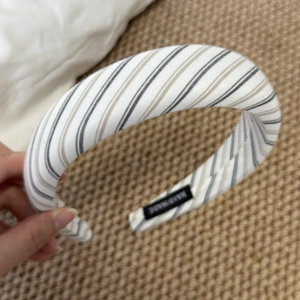 Detailed macro view of handmade striped padded headband with soft cotton texture and inner label