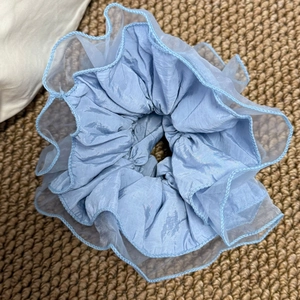 Détail d'un chouchou bleu clair multicouche avec tissu organza et bordures volantées