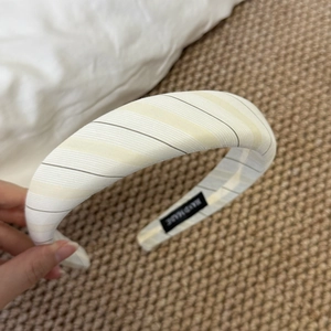 Detail of yellow and white striped sponge headband with handmade label inside