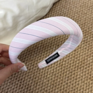 Detail view of a handmade pink and white striped padded headband with textile texture
