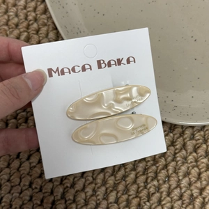 Detailed macro of marble texture hair clips with Barrette La France text engraving