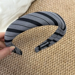 Detail of grey striped sponge headband with thick padded texture on woven background