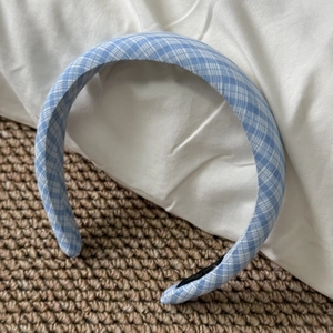 Detail showing blue and white plaid fabric headband with non-slip lining on woven mat