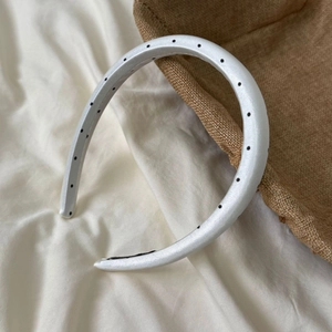 Detailed view of the white satin headband with black polka dots and anti-slip lining