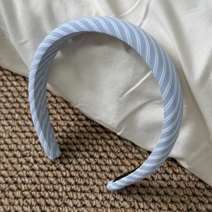Close-up detail of light blue and white striped fabric texture on a wide padded headband