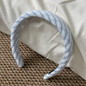Detail of blue and white striped fabric headband with textured pleats and soft lining