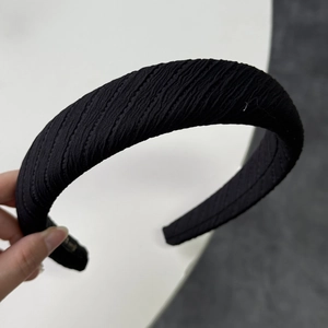 Detail of black wide headband featuring thick ribbed knit texture and sponge padded design