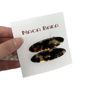 Set of two tortoise shell acetate leaf hair clips on a white card display