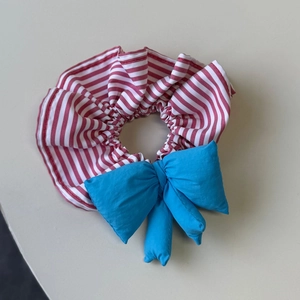 Charming red and white striped hair scrunchie with a large blue 3D padded bow accent