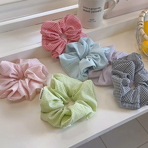 Set di sei elastici per capelli a quadretti in vari colori sul davanzale bianco