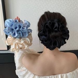 Three oversized pleated satin scrunchies in blue, beige, and black for elegant hairstyling