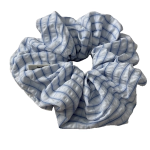 Blue and white plaid scrunchie with pleated fabric texture for elegant hair styling