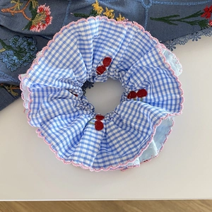 Chouchou à carreaux bleus et blancs avec broderie cerise et bords festonnés roses