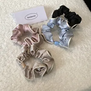 Elegant four-piece set of satin hair scrunchies in classic colors with white contrast edges