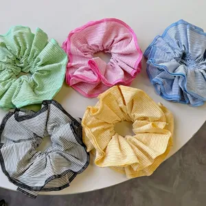 Five colorful striped scrunchies in green pink blue black and yellow on white background
