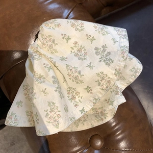Floral fabric bucket hat in cream color with delicate pink and green flower patterns