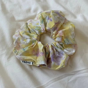 Detailed macro view of the floral fabric scrunchie with yellow and purple flower patterns
