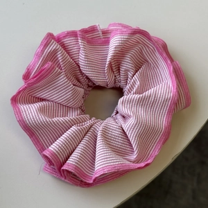 Detailed close-up of pink and white striped scrunchie with soft pleated texture