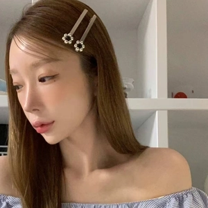 Barrettes à fleurs argentées avec perles portées sur de longs cheveux de femme