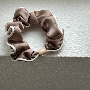 Elegant champagne satin hair scrunchie with white piped edges and smooth beige buckle
