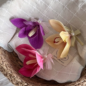 Elegant magnolia flower hair clips with silk ribbons and pearl accents in three colors