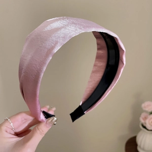 Detail view of pink satin wide headband showing non-slip inner teeth and silk texture